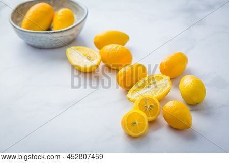Small citrus fruits limequat with bowl on table