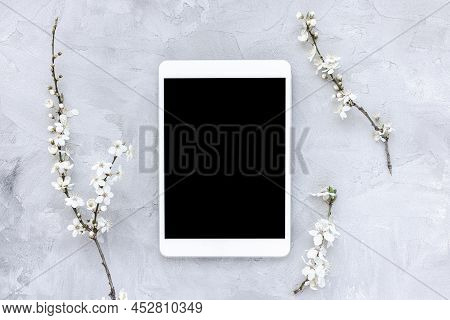 Digital Tablet Mock-up And Spring White Cherry Blossom Flowers On Gray Background. Online Shopping, 