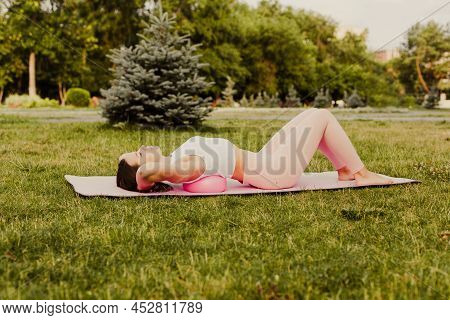 Attractive, Flexible Caucasian Woman Do Pilates With Ball And Stands In Bridge For Stretching Spine 