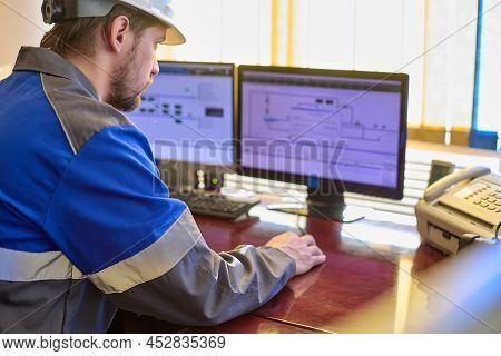 Worker In Overalls Uses A Linear Telemechanics System To Control The Technological Processes Of The 