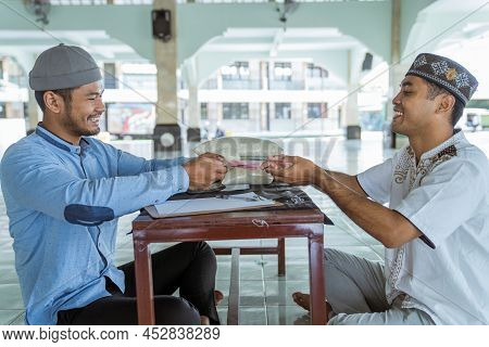Muslim Paying Some Zakat Charity Using Cash At The Mosque