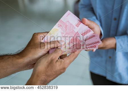 Muslim Paying Some Zakat Charity Using Cash At The Mosque