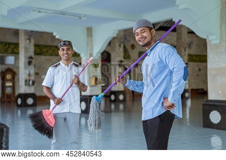 Muslim Male Cleaning The Mosque Using Broom And Sweeping The Floor