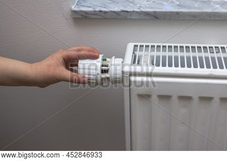 Close Up View Of Hand On Thermoregulator Of Heating Element.