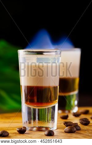 Shots Of Flaming B-52 Cocktail Placed On A Bar Counter. B-52 Shot Composed Of Three Liqueurs
