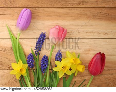 Collection Of Colorful Spring Flowers On Wooden Background, Top View Of Early Bloomers At Easter Tim