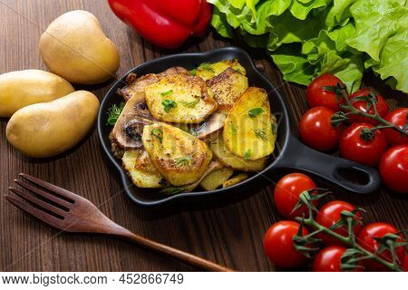Baked Gratin Dauphine At Home On A Wooden Table With Cherry Tomatoes.