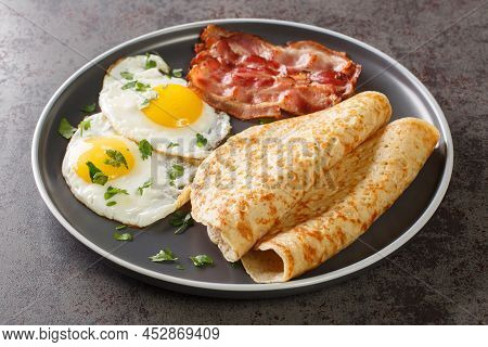 Delicious Oatcakes Served With Egg And Bacon Close-up In A Plate On The Table. Horizontal