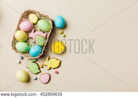 Colorful Easter Cookies In Basket With Multi Colors Easter Eggs On Colored Background . Pastel Color