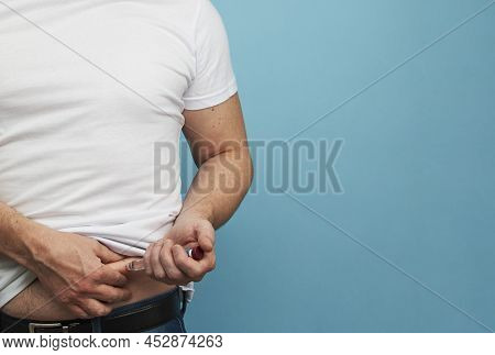 Man Doing Insulin Injection Pen, Close-up, Blue Background