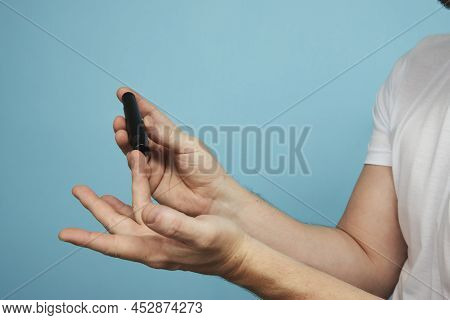 Man With Lancet Pen Doing Diabetes Test, Close-up