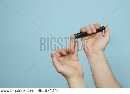 Man With Lancet Pen Doing Diabetes Test, Close-up