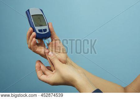 Woman Checking Blood Sugar Level With Glucometer