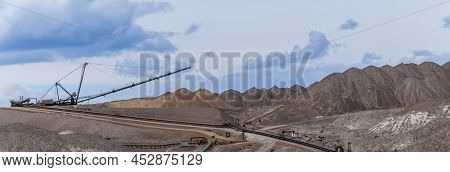 Giant Spreader Or Absetzer Machinery. A Large Dumper On A Landfill With Potash Ore. Extracting And M