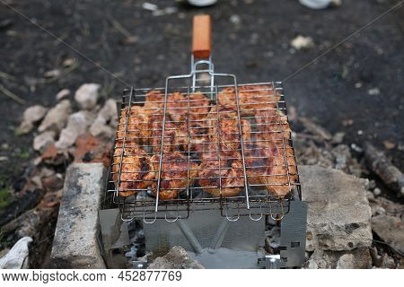 Metal Grill For Barbecue. Shish Kebab In Marinade Is Cooked On The Grill. Fried Chicken Meat With Sp