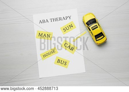 Taxi Car Model And Paper Sheet With Phrase Aba Therapy On White Wooden Table, Flat Lay