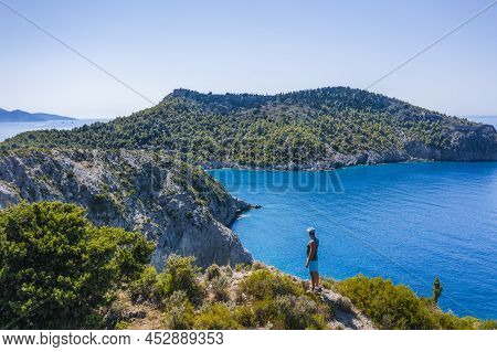 Aerial Photo Of Man Traveler On The Cliff Edge Of Beautiful And Picturesque Rocky Coast Close To Ass