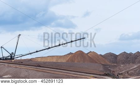Giant Spreader Or Absetzer Machinery. A Large Dumper On A Landfill With Potash Ore. Extracting And M