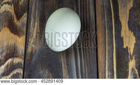 Araucana Egg On Wooden Background. Light Blue Egg From Araucana Chicken. Easter Festival Concepts. E