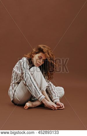 Portrait Of Young Ginger Woman In Casual Suit Looking Very Sad Isolated On Beige Brown Background