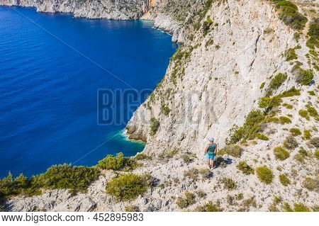 Aerial Photo Of Man Traveler On The Cliff Edge Of Beautiful And Picturesque Rocky Coast Close To Ass