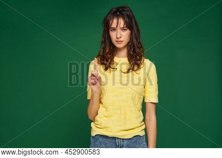 Serious Girl Showing Admonishing Finger Gesture, Saying No, Be Careful, Raised Up Forefinger. Author