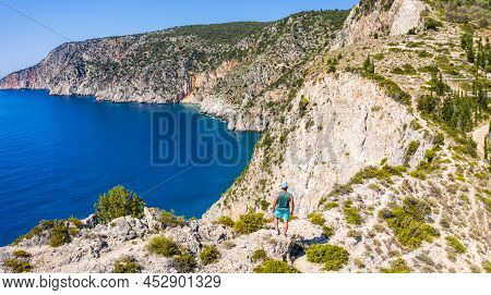 Aerial Photo Of Man Traveler On The Cliff Edge Of Beautiful And Picturesque Rocky Coast Close To Ass