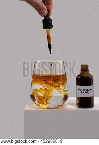 Iodide Tablets Liquid For Use In Case Of Radioactive Contamination. A Hand Drips Drops From A Pipett