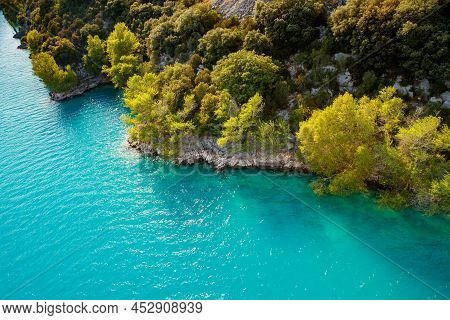Azure Water Of The Lake And Slopes Of Mountains On A Background, Coast Line, Green Trees, Sun Light