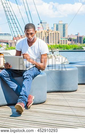Young African American Man Traveling In New York, Wearing White T Shirt, Blue Pants, Boot Shoes, Sit