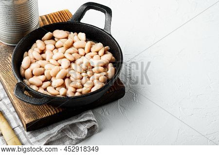 White Canned Beans Set, With Metal Can, In Cast Iron Frying Pan, On White Stone  Surface, With Copy 