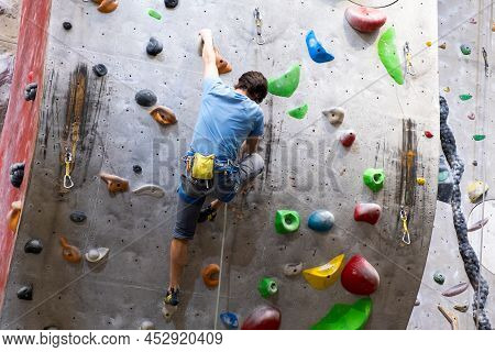 The Climber Trains On The Artificial Rock Wall With Insurance In Bouldering Gym, April 2022, Prague,