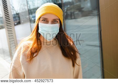 Cheerful Young Woman In Yellow Hat With Protective Mask On Her Face. Virus Spread Flu Prevention Car
