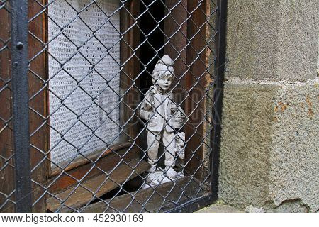 Rupit, Spain - September 09, 2014: Boy And Dog Statue Looking Through Window Guard In Rupit