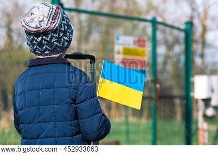 Warsaw, Poland - April 7 2022: Child Or Kid With Luggage, Suitcase Or Bag, Winter Clothes, Hat And U