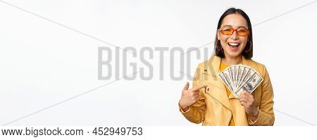 Microcredit And Money Concept. Stylish Asian Young Woman In Sunglasses, Laughing Happy, Holding Doll