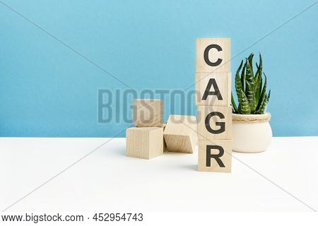 Cagr - Word Is Written On Wooden Cubes Close-up. Bright Blue Background. White Surface Table. In The