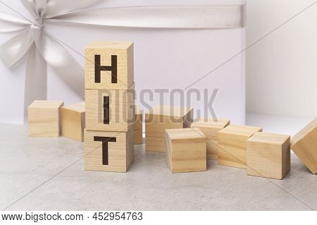 Hit - Letters On Wooden Cubes. Concept On Light Gift Box Background. Business As Usual Concept Image