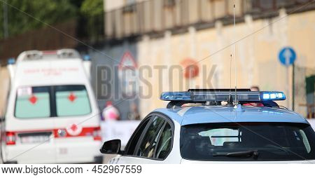 Police Car With Blue Flashing Lights On It While Escorting An Ambulance To Go To The Hospital After 