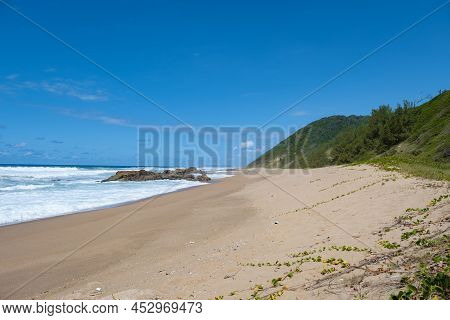 St Lucia South Africa, Rocks Sand Ocean, And Blue Coastal Skyline At Mission Rocks Beach Near Cape V