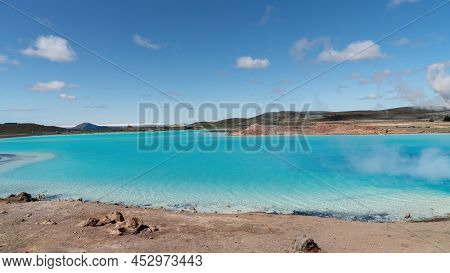 Blue Lake In Hverir Myvatn Geothermal Area With Boiling Mudpools And Steaming Fumaroles In Iceland