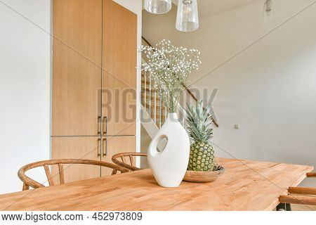 Interior Of The Dining Area Next To The Stairs To The Top And A Vase Of Flowers On The Table