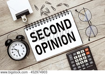 Second Opinion Text On An Open Notepad On A Light Table Near A Calculator And Glasses