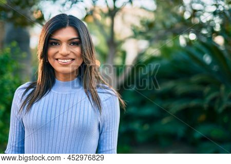 Beautiful hispanic woman smiling confient at the park