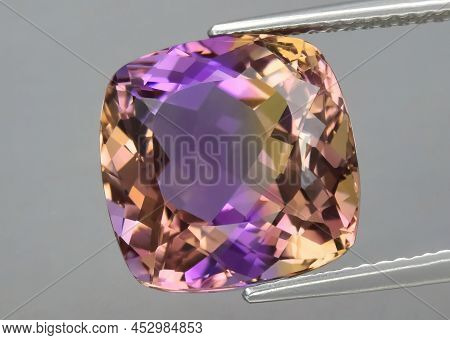 Natural Gemstone Colored Ametrine In Thongs On A Gray Background. Natural Bolivian Bicolor Yellow Pu