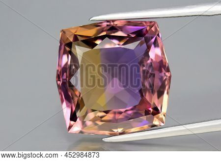 Natural Gemstone Colored Ametrine In Thongs On A Gray Background. Natural Bolivian Bicolor Yellow Pu