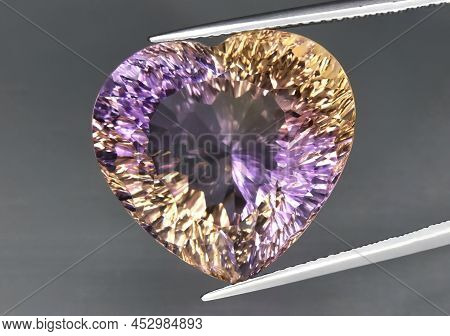 Natural Gemstone Colored Ametrine In Thongs On A Gray Background. Natural Bolivian Bicolor Yellow Pu