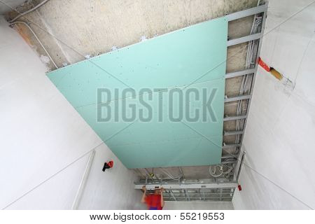 The wage workers install the ceiling profile in the new apartment 