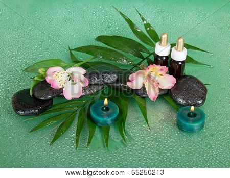 Candles, aroma oil, stones and flowers
