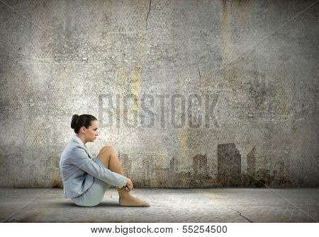 Image of young upset businesswoman sitting alone